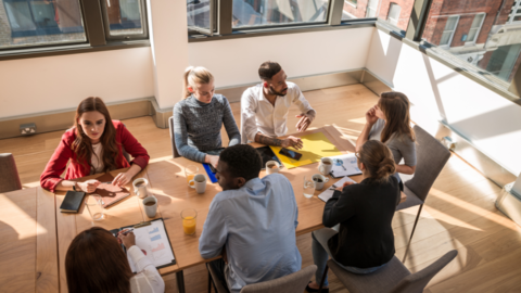 Group sitting at table in conversation.