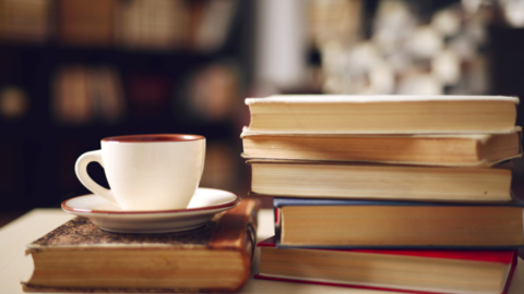Books stacked next to coffee cup