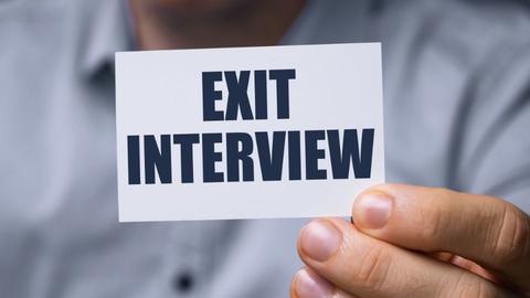 Man holding card that reads Exit Interview