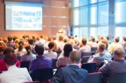People listening to a conference presentation