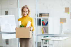 woman carrying box out of office