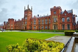 A university campus with red-brick buildings and a green lawn