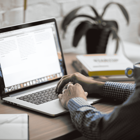 Man typing at computer laptop.